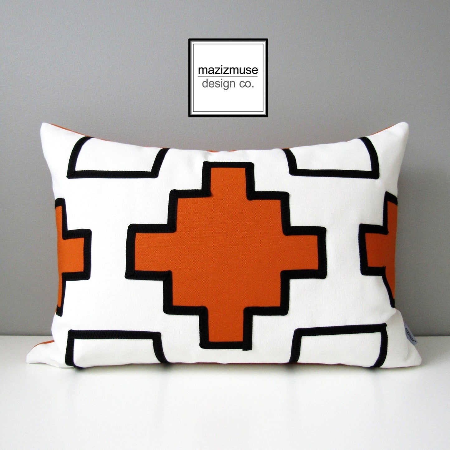 black and white outdoor pillowwith orange sunbrella design in aztec style.