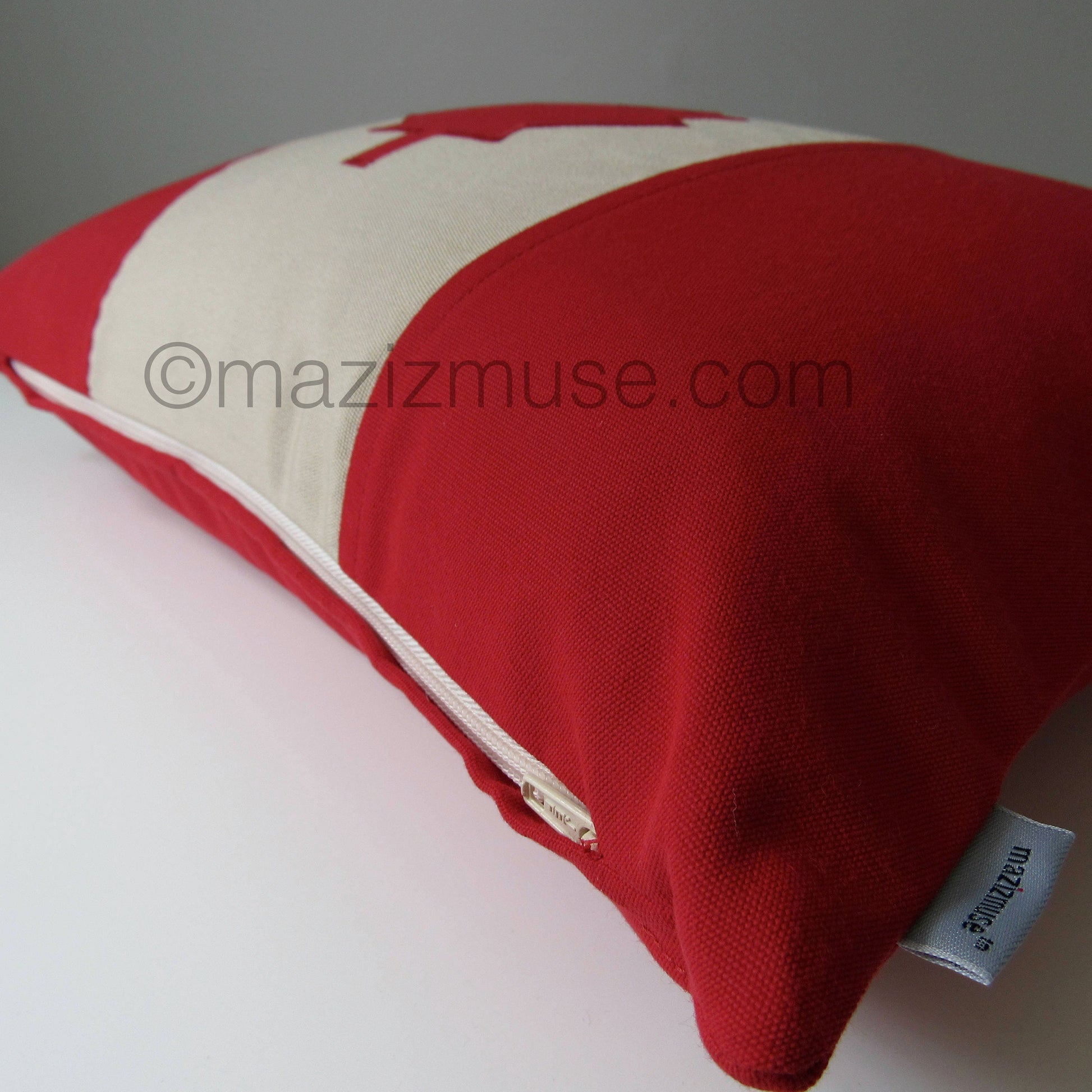 Red and antique beige Canada flag pillow in outdoor sunbrella fabric for porch and patio seating.