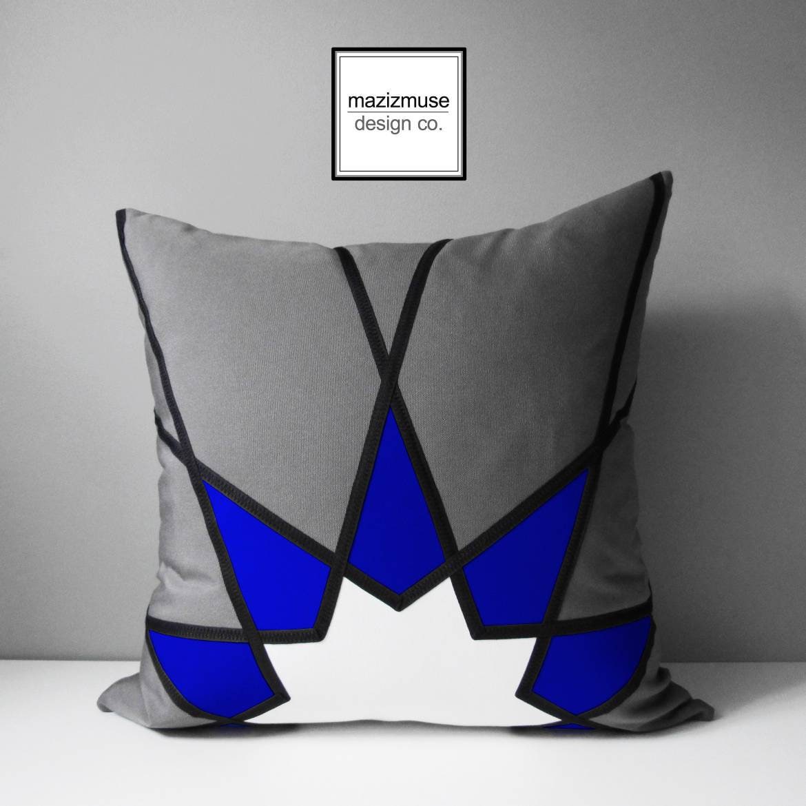 grey and blue sunbrella outdoor pillow cushion with white sunburst. modern cushions for patio and indoor living spaces