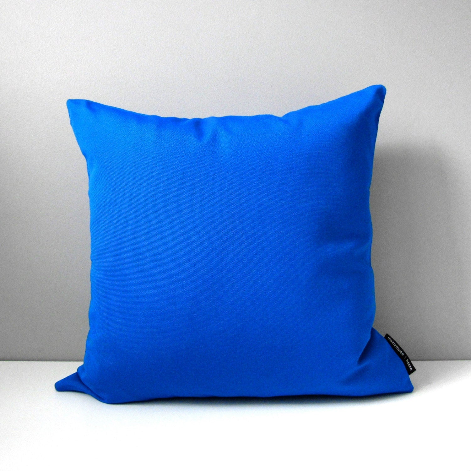 solid cobalt blue sunbrella outdoor pillow for modern patio and poolside seating