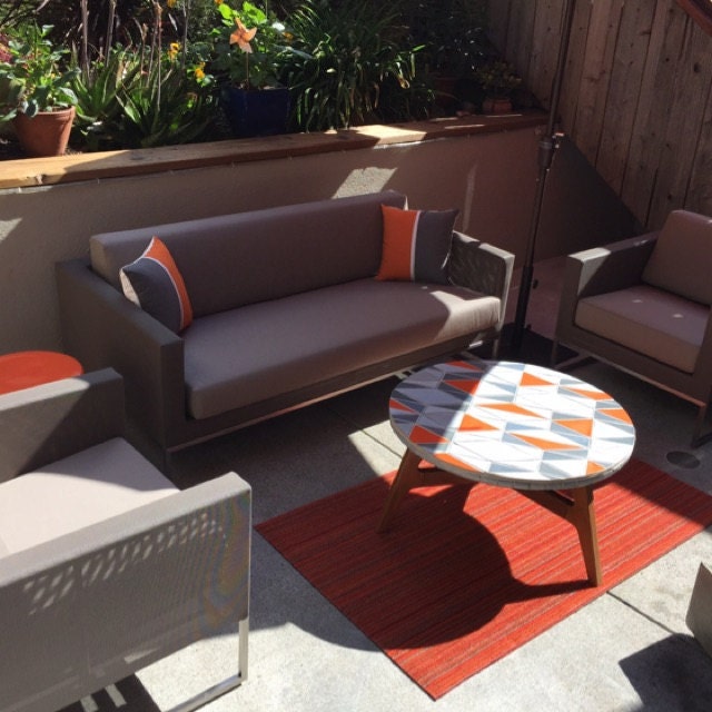 grey and orange colorblock sunbrella pillows on a outdoor sofa