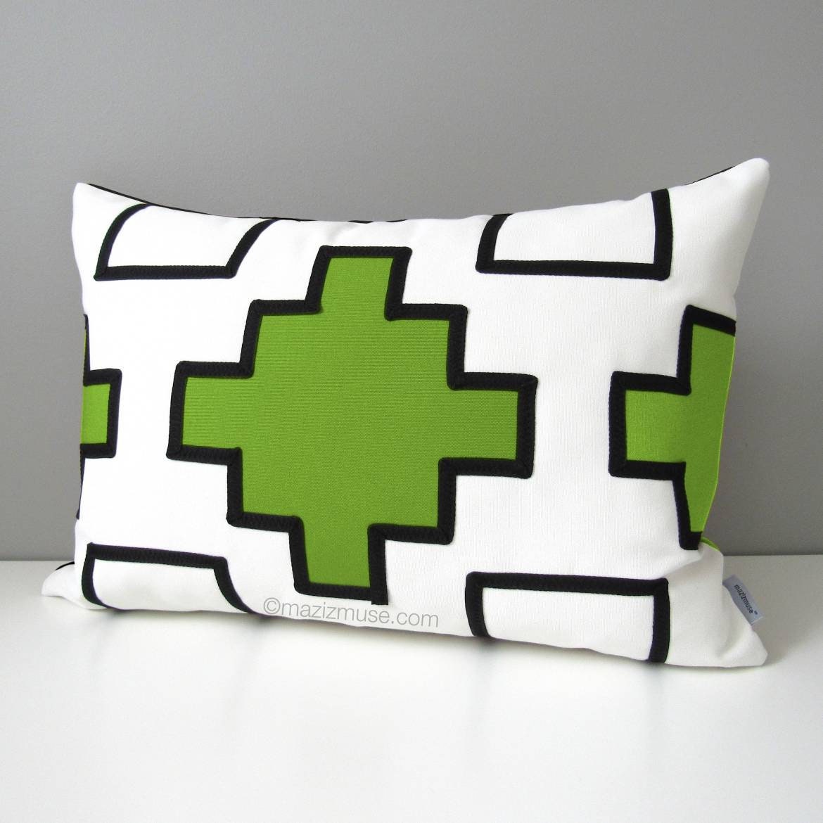 white and lime green outdoor pillow with black trim detail